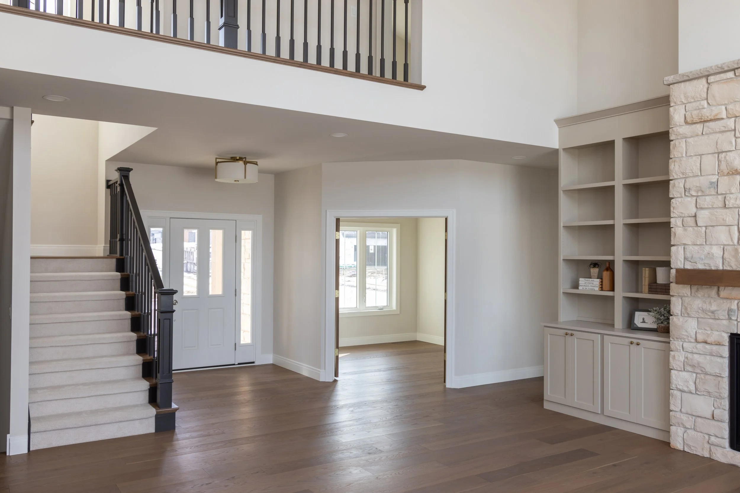 Open concept living area with brick fireplace and stairs to upper level