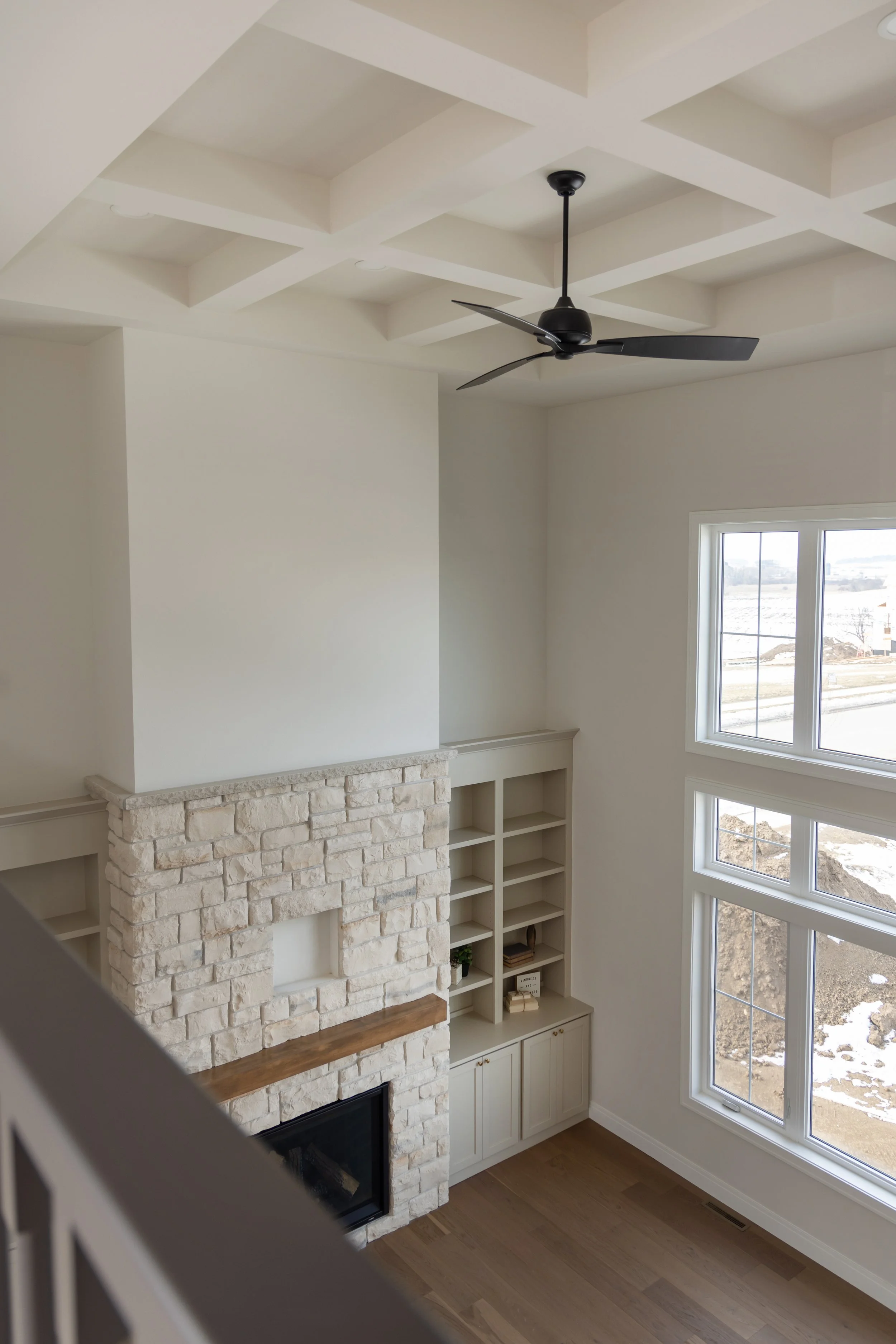 View from stair railing looking down on a living room with woodenfloor