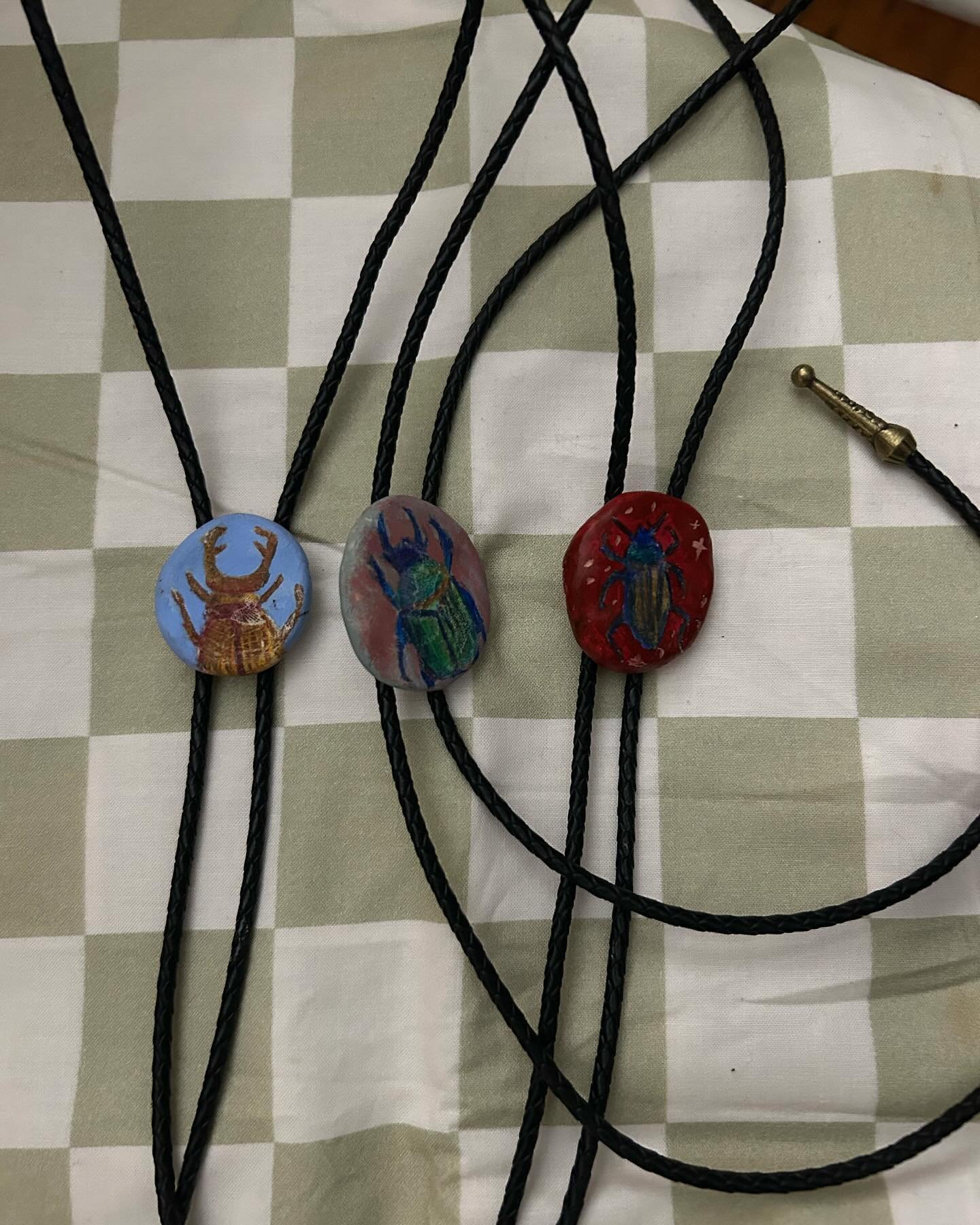 Hand painted pins and beetle bolos!! for sale starting this saturday 🥳