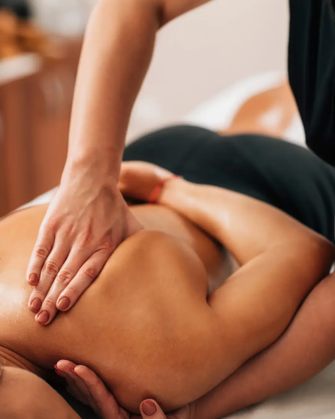Close-up of a massage therapist's hands giving a massage to a person's back.