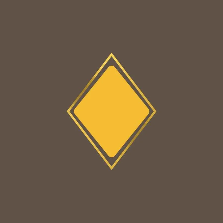 Yellow diamond-shaped road sign on a brown background.