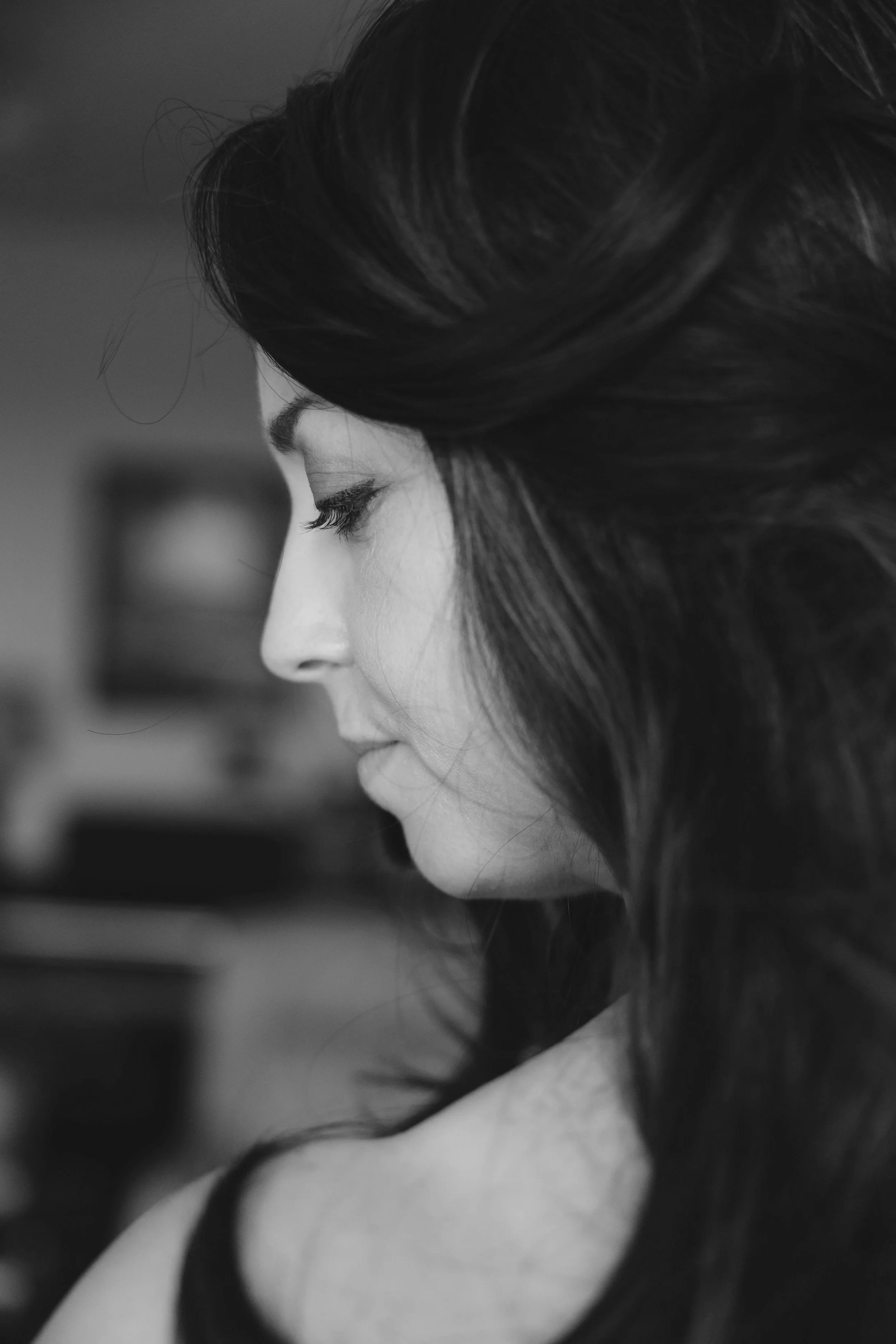 A black-and-white profile of a woman with long dark hair, closed eyes, and a calm expression.