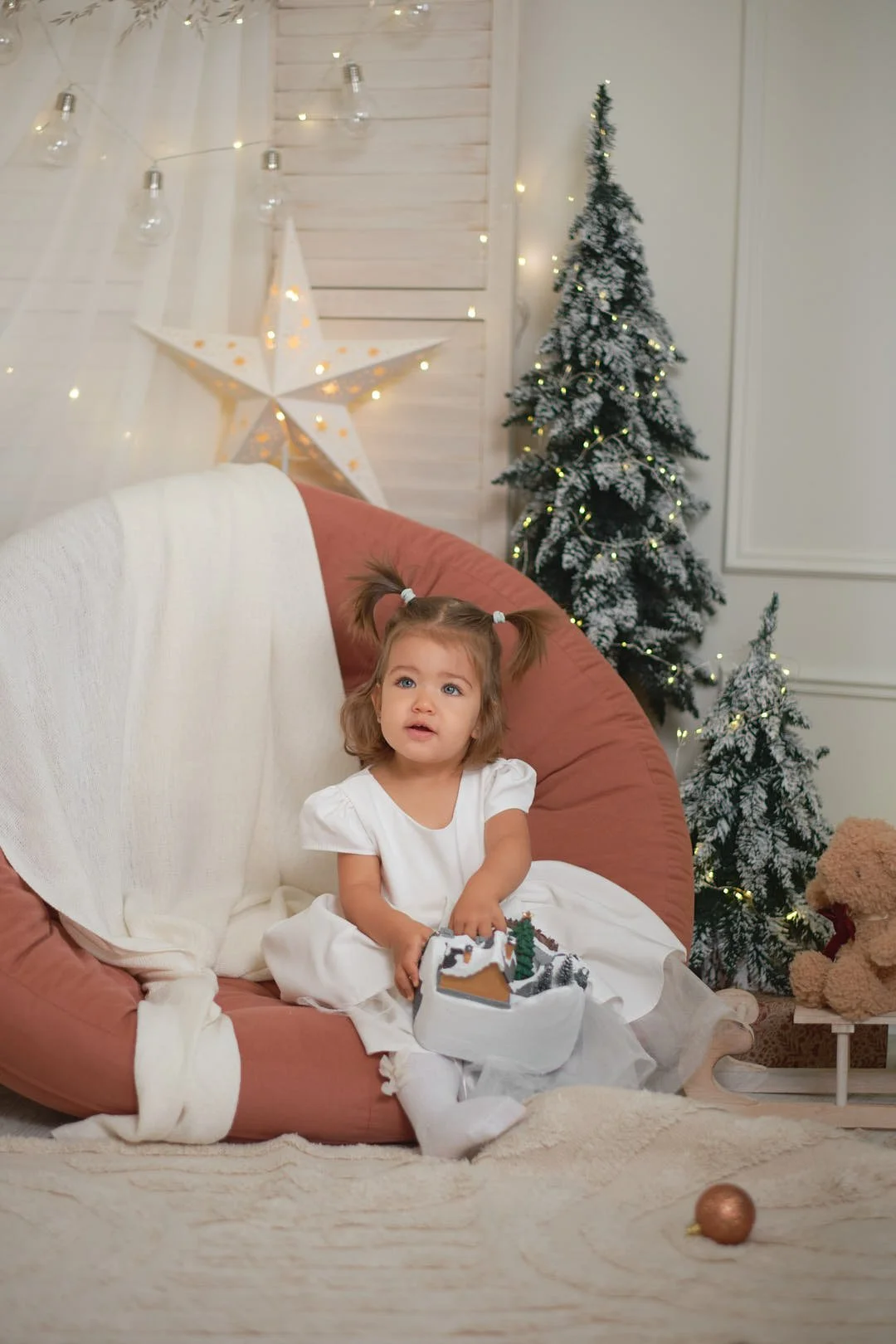 едногодишно дете си играе с играчка коледно селце
