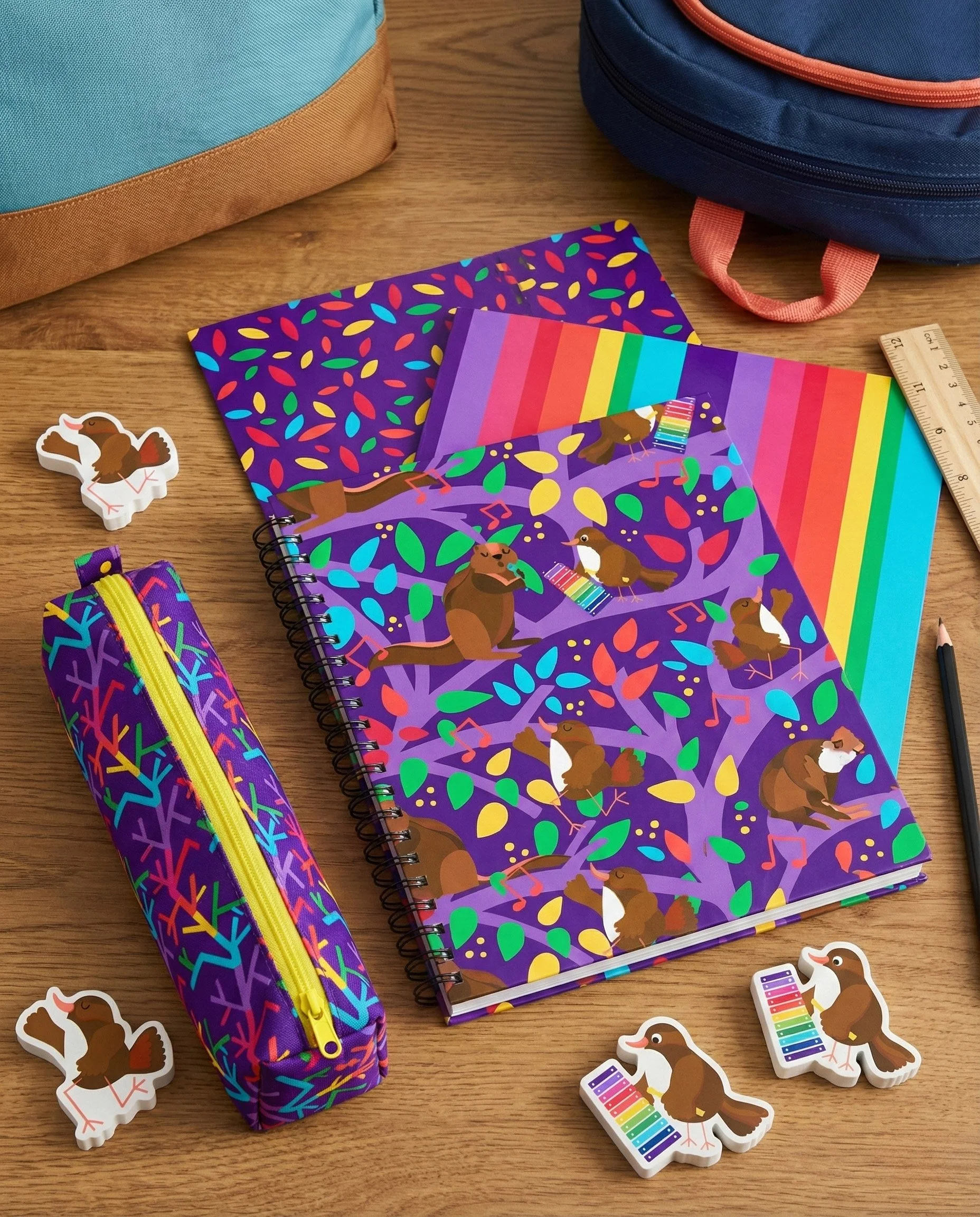 Playful  bird and squirrel musical woodland pattern showcased on notebooks, stationery, and school accessories, featuring charming animal characters, colorful leaves, and rhythmic musical notes on a purple background. This versatile surface design is