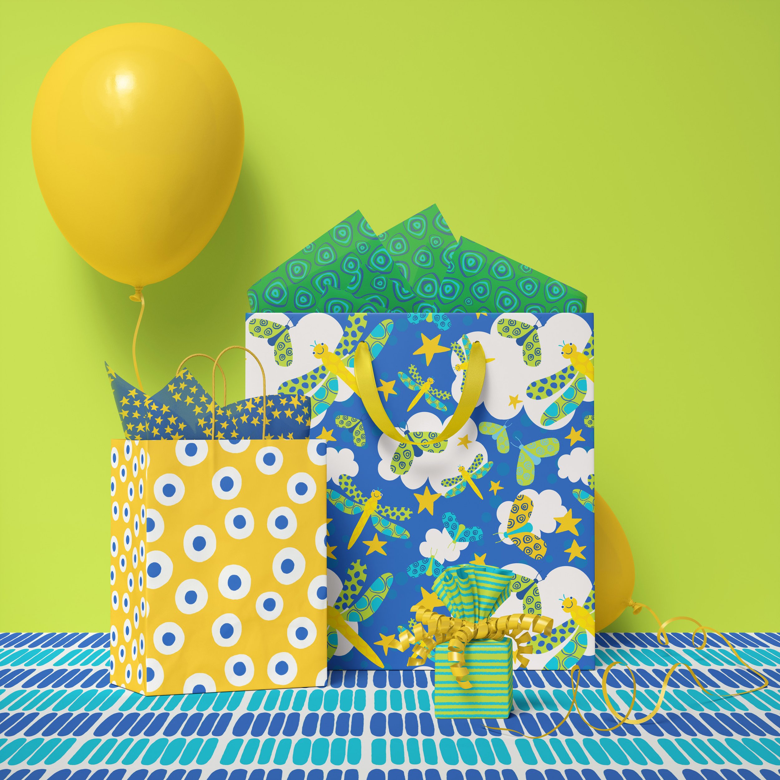Colorful gift bags with dragonfly and cloud patterns, a yellow balloon, and a wrapped present with a ribbon, all set on a patterned table against a lime green background.