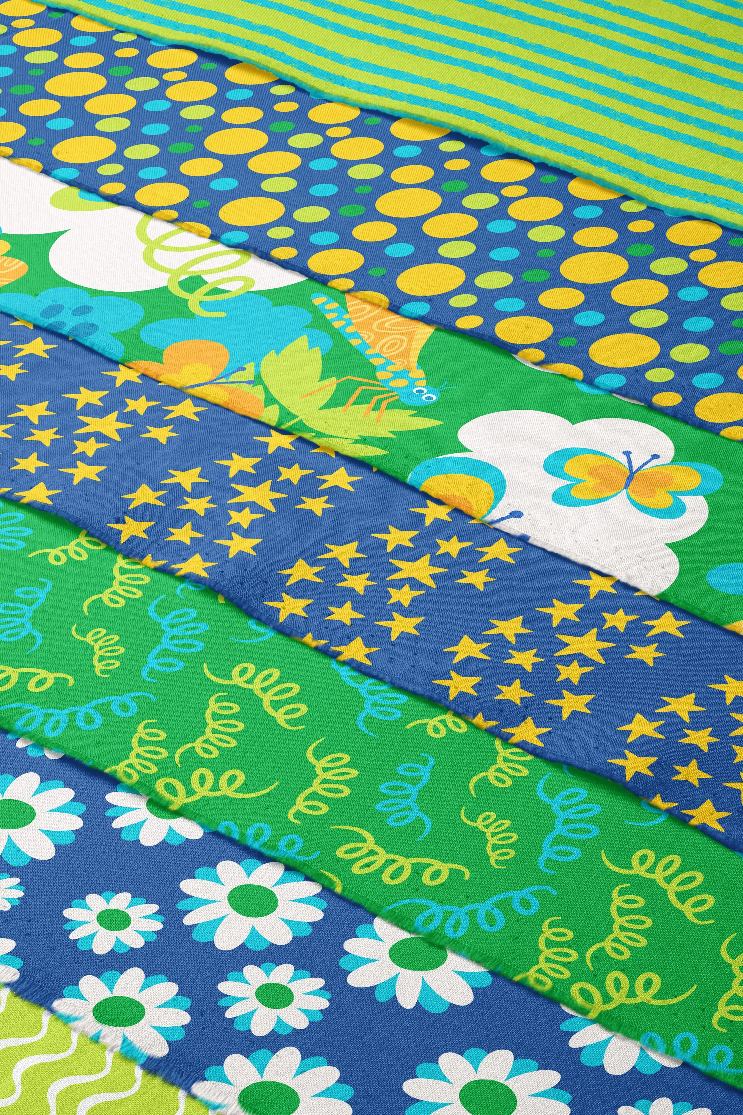 Colorful fabric strips with various playful patterns, including polka dots, butterflies, stars, swirls, and daisies.