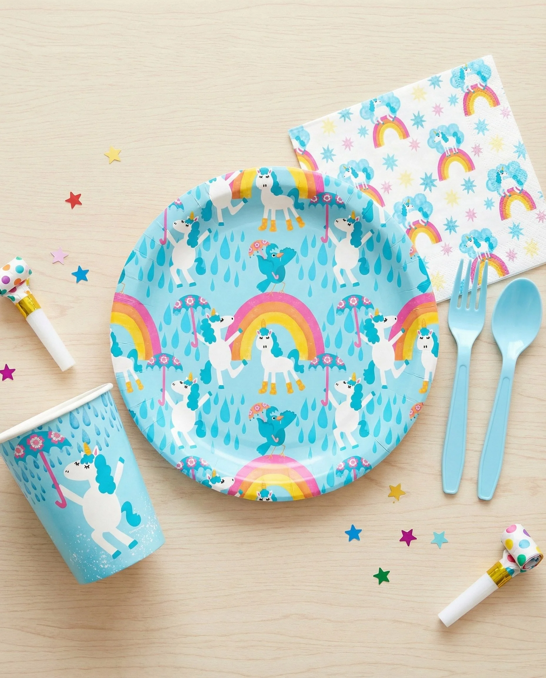 Unicorn birthday party tableware featuring unicorn plates, cups, napkins, and rainbow patterns