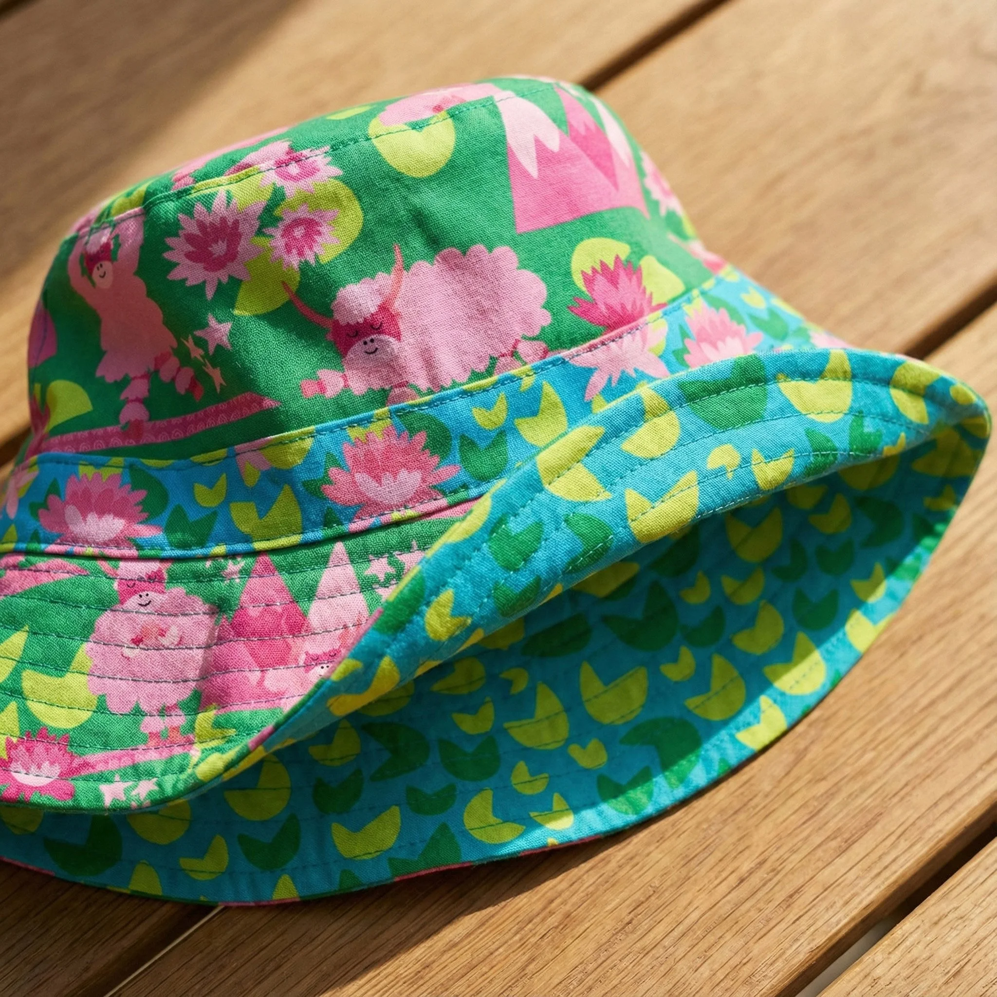 Yak-a-Doodle Yoga surface pattern designs showcased on a children’s bucket hat, featuring whimsical yak illustrations, lotus florals, mountain motifs, and organic shapes for playful kids accessories and licensed apparel products.