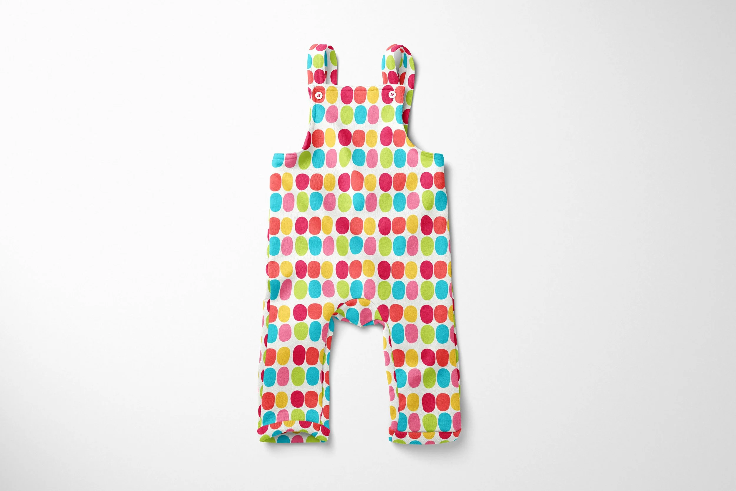 toddler overalls featuring a bright, geometric pattern on a white background. The design consists of rows of vertical oval dots in alternating vibrant shades of pink, red, yellow, turquoise, and lime green. The overalls have a classic bib front with 