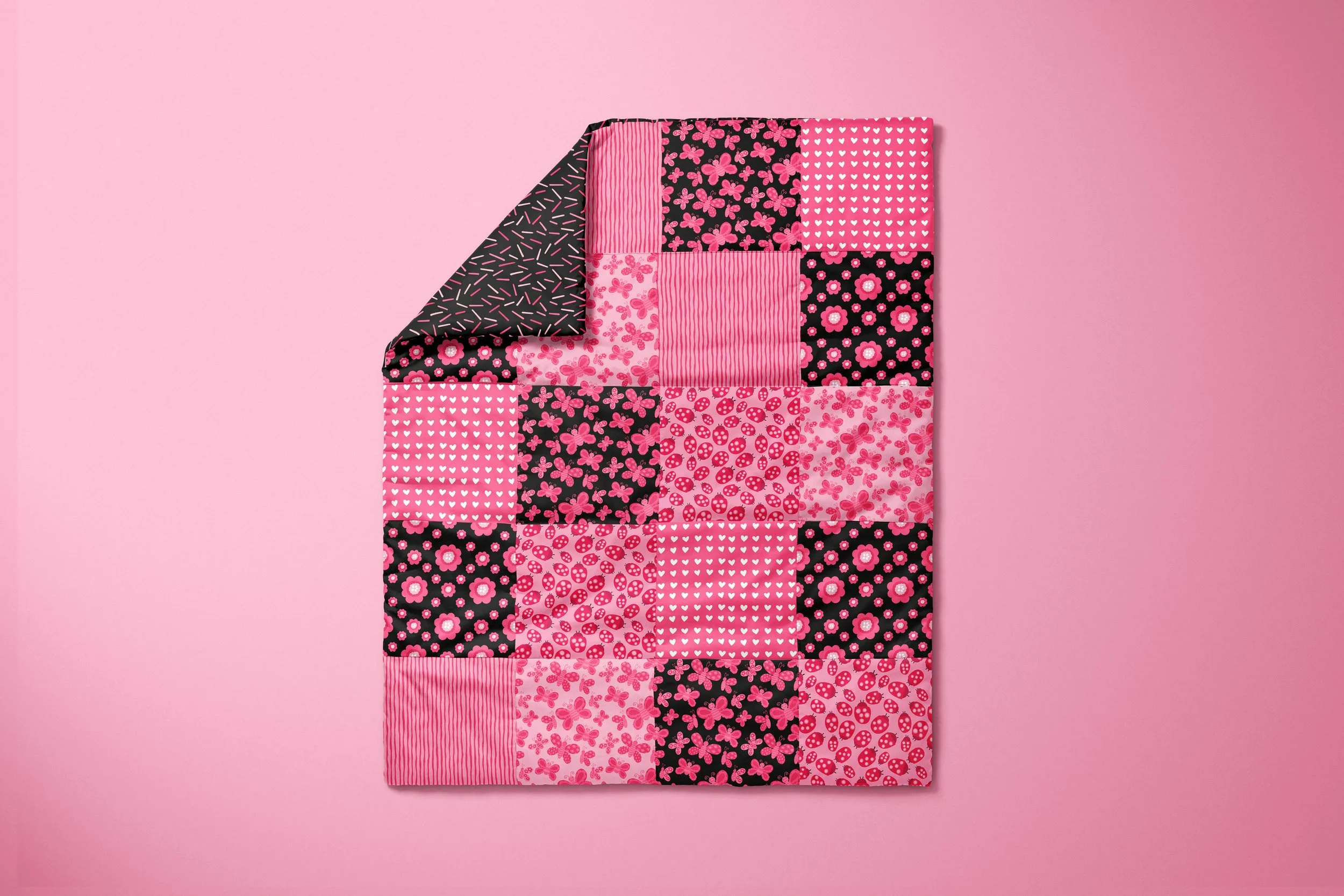 Patchwork quilt showcasing a variety of coordinating ladybug, butterfly, floral, heart, and stripe patterns from the Love and Ladybugs collection. Whimsical surface designs created for quilts, bedding, home décor, and joyful textile licensing inspire
