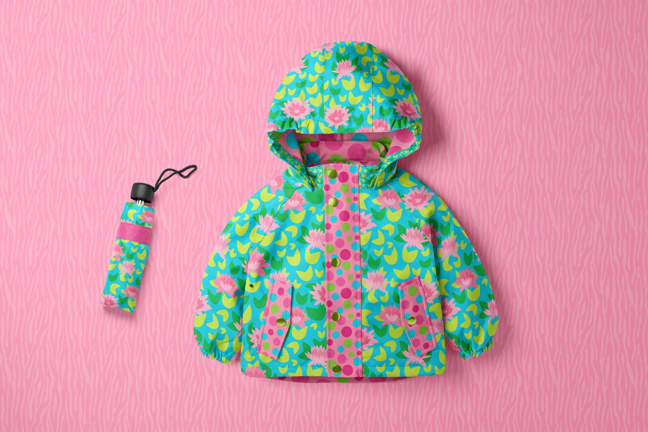 lotus floral patterned child's raincoat with matching umbrella. Color palette is tones of pinks, turquoise and mint greens. pattern of playful polka dots in bright pinks and pretty coordinating colors. Pop of pink lotus flowers. Background is hand dr
