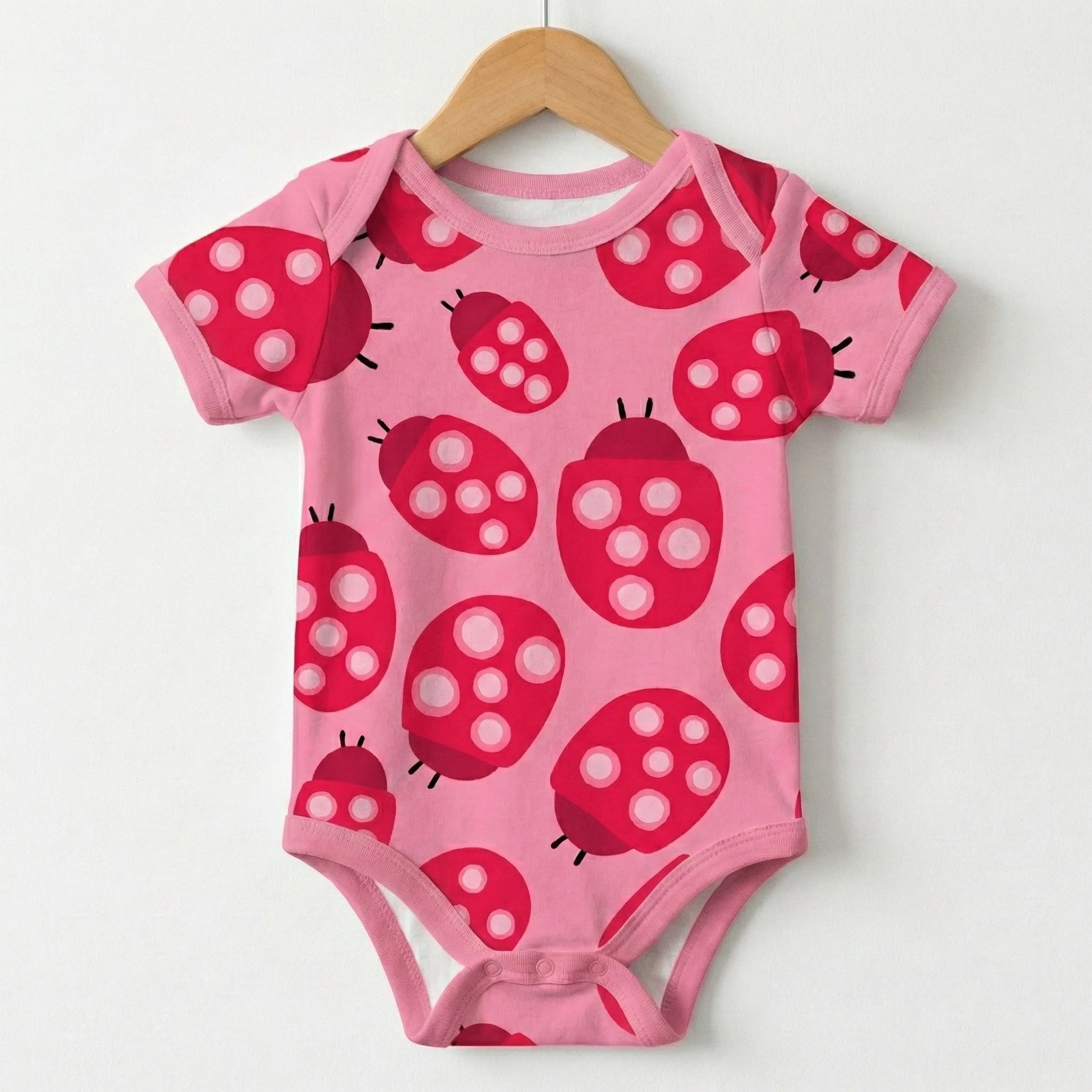 Adult and child aprons featuring a whimsical ladybug and heart pattern from the Love and Ladybugs fabric collection