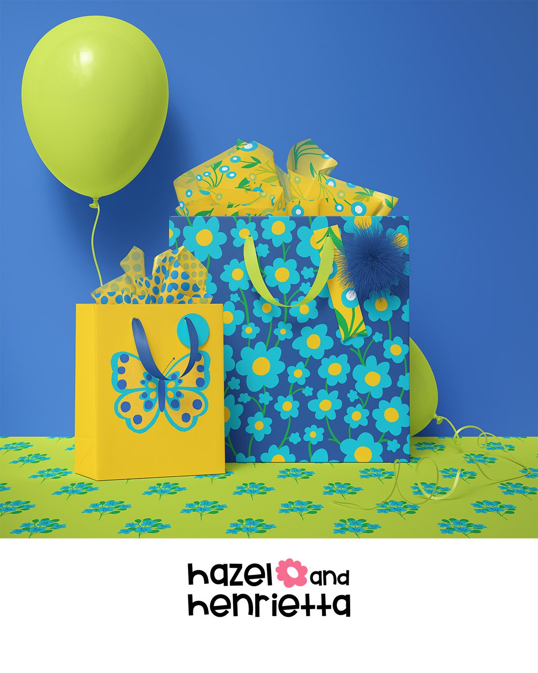 Bright yellow and blue gift bags with floral and butterfly patterns, yellow and green balloons, set on a yellow tablecloth with blue flowers, and the text 'hazel and henrietta' at the bottom.