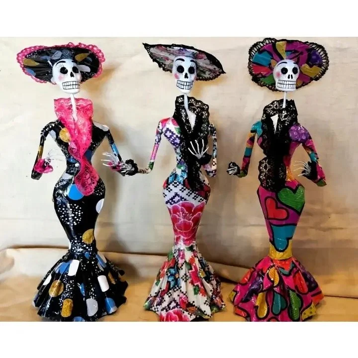 Colorful Day of the Dead Catrina figurines with skeleton faces and decorative dresses.