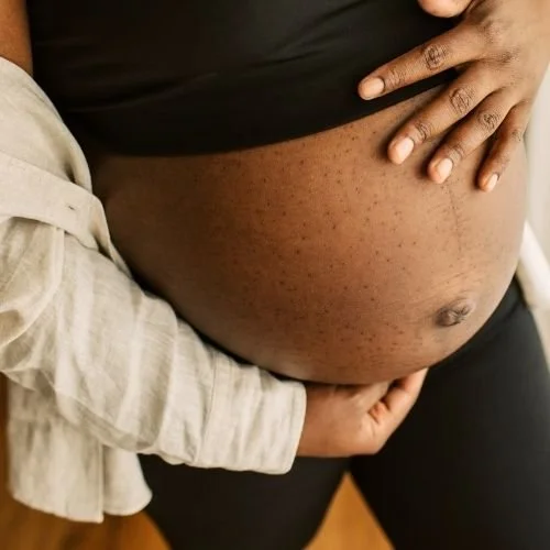 black woman holding her pregnant belly