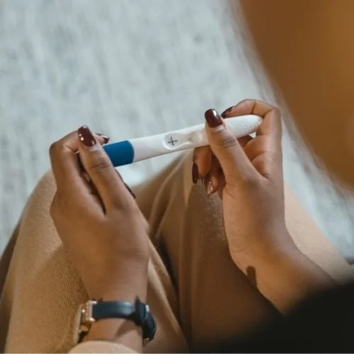 latino woman's hands holding a pregnancy test