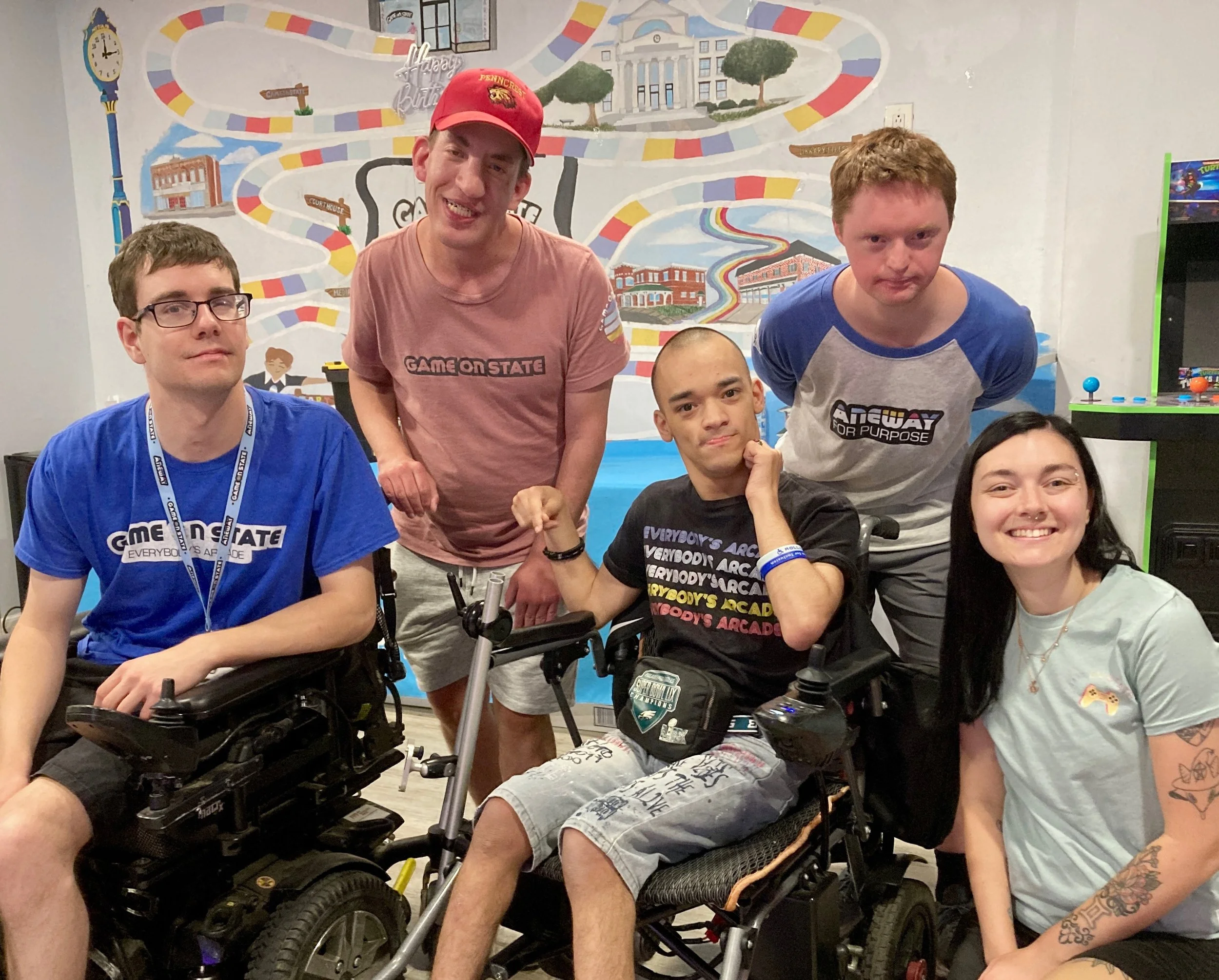 A group of five Aneway employees smile into the camera
