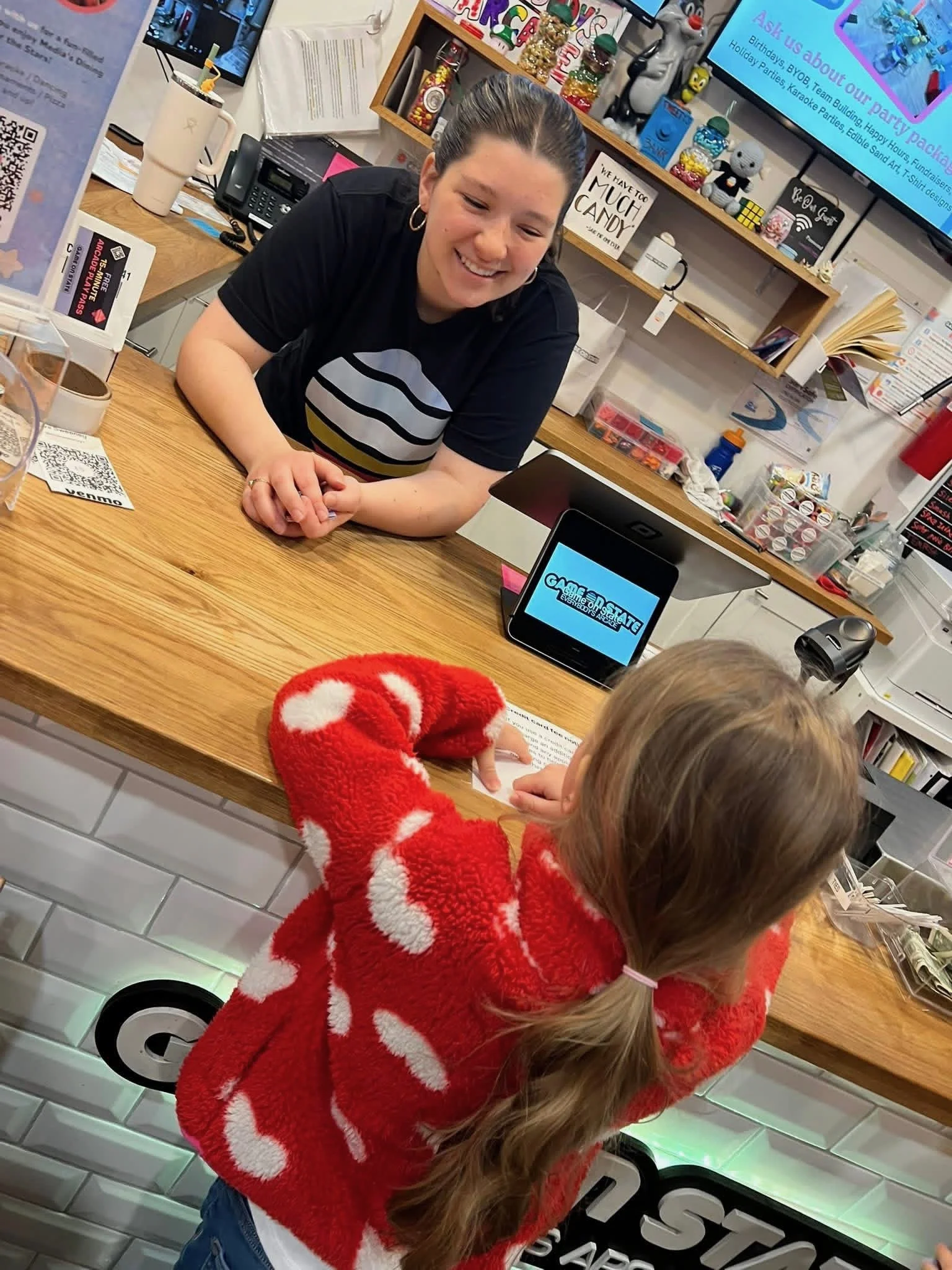 A GOS employee and young girl smile at each otherle a