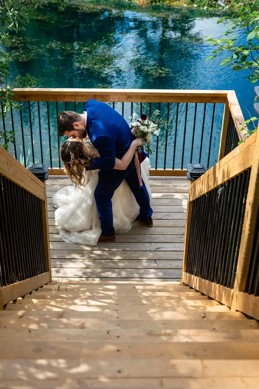 pine-and-pond-wedding-viewing-deck-couple-kiss-pond.webp