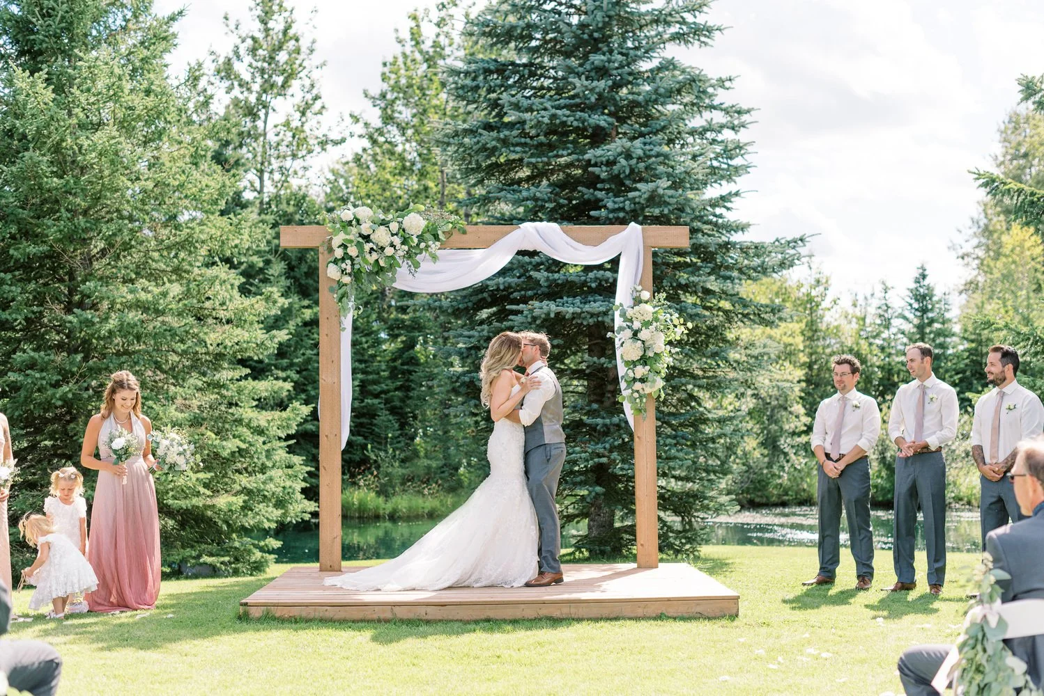 pine-and-pond-outdoor-wedding-ceremony-at-wooden-arbor.jpg