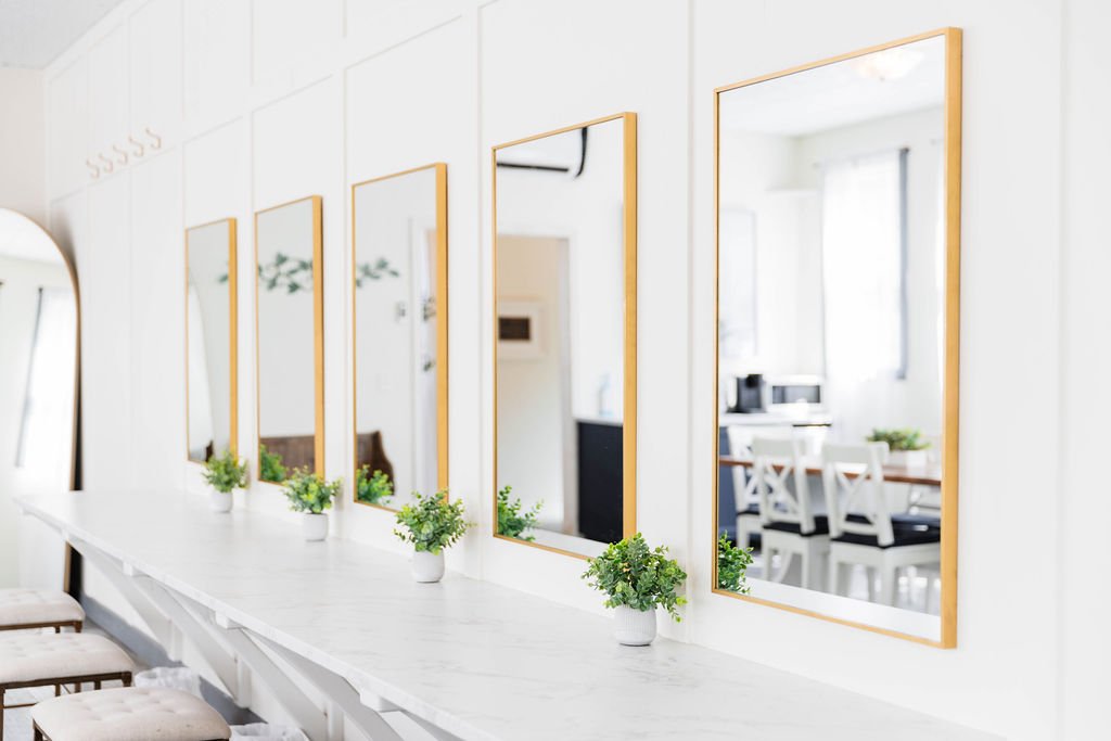 Minimalist bridal beauty station with multiple gold-framed mirrors and soft greenery décor inside the Pine and Pond getting-ready room, ideal for hair and makeup on the wedding day.