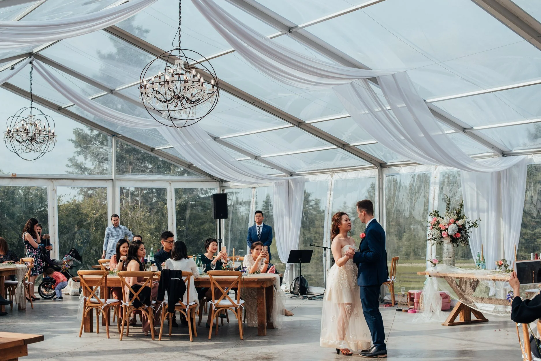 First dance in a clear reception tent surrounded by greenery