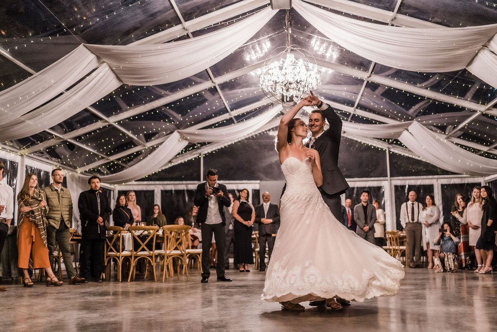 Bride and groom sharing their first dance inside a clear tent at a destination wedding venue near Edmonton and Calgary, Alberta
