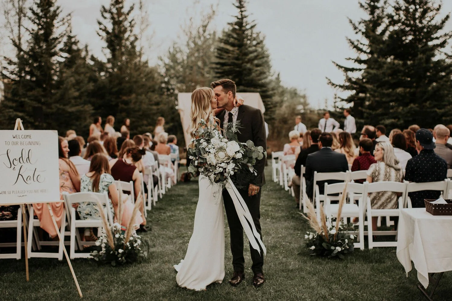 Bride and groom kissing at their ceremony recession walk