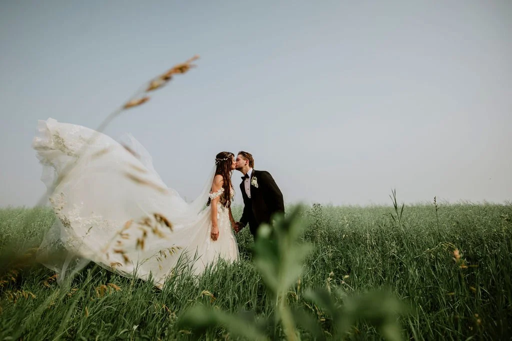 bride-groom-kissing-wildflower-field-central-alberta-wedding.jpg