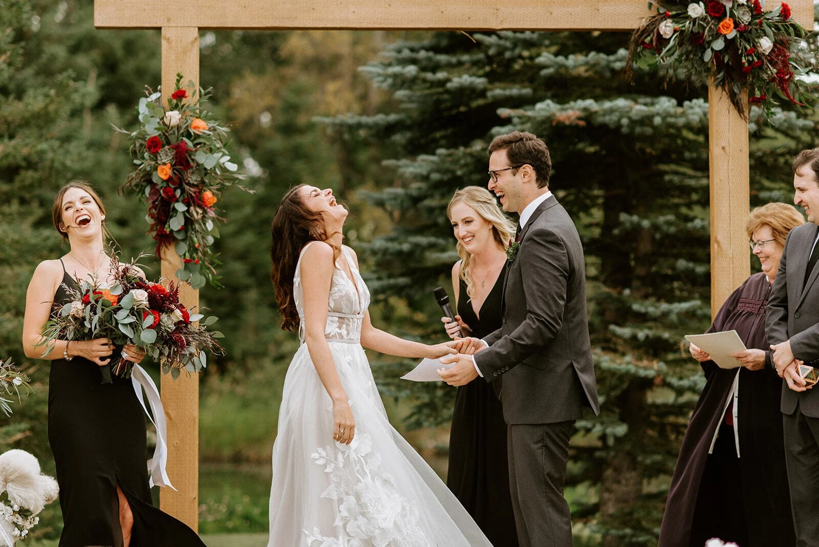 Bride laughing during wedding vows at an outdoor ceremony at Pine and Pond