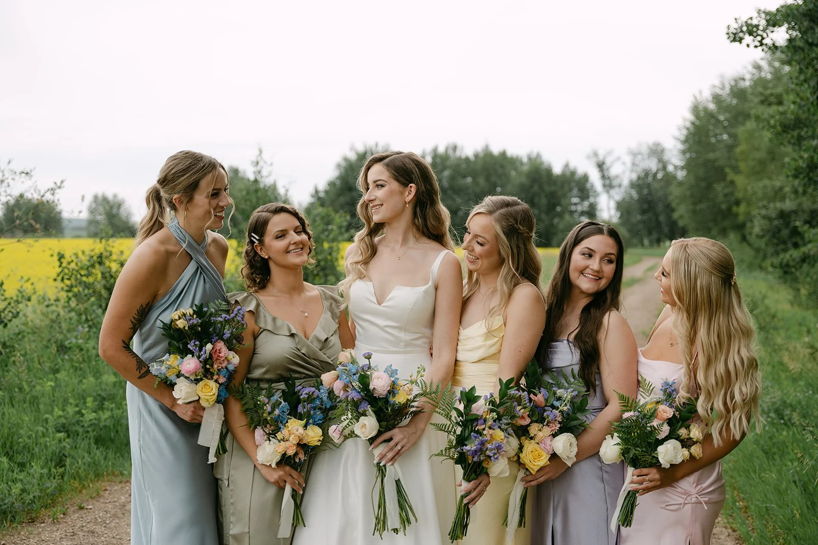 pine-and-pond-wedding-bride-with-bridesmaids-natural-field.jpg