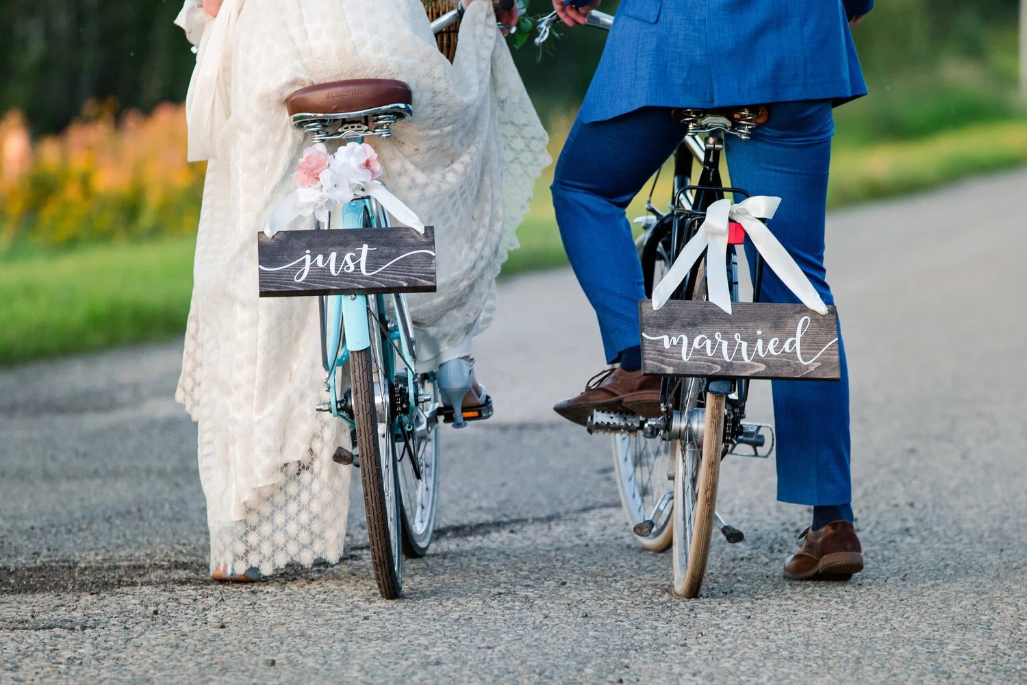 Bride and groom riding bicycles with just married signs at a destination wedding venue near Edmonton and Calgary, Alberta