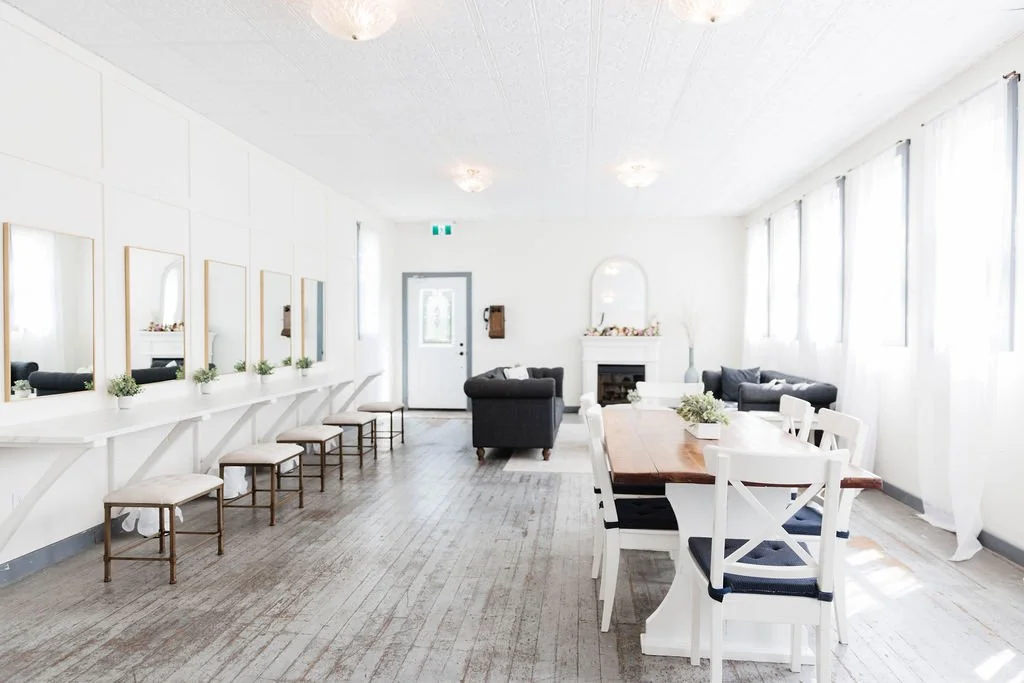 Spacious bridal cottage interior at Pine and Pond featuring a cozy lounge area, white fireplace mantel, and natural light — an inviting setting for bridesmaids and family on the wedding morning.