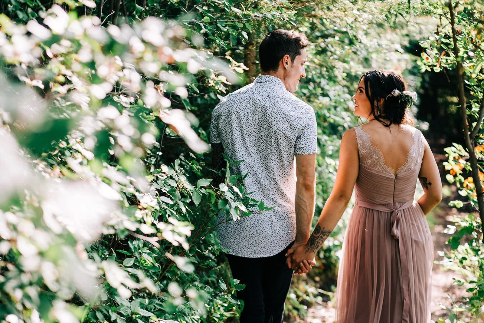 Bride and groom walking along a forest path at Pine and Pond Wedding Venue