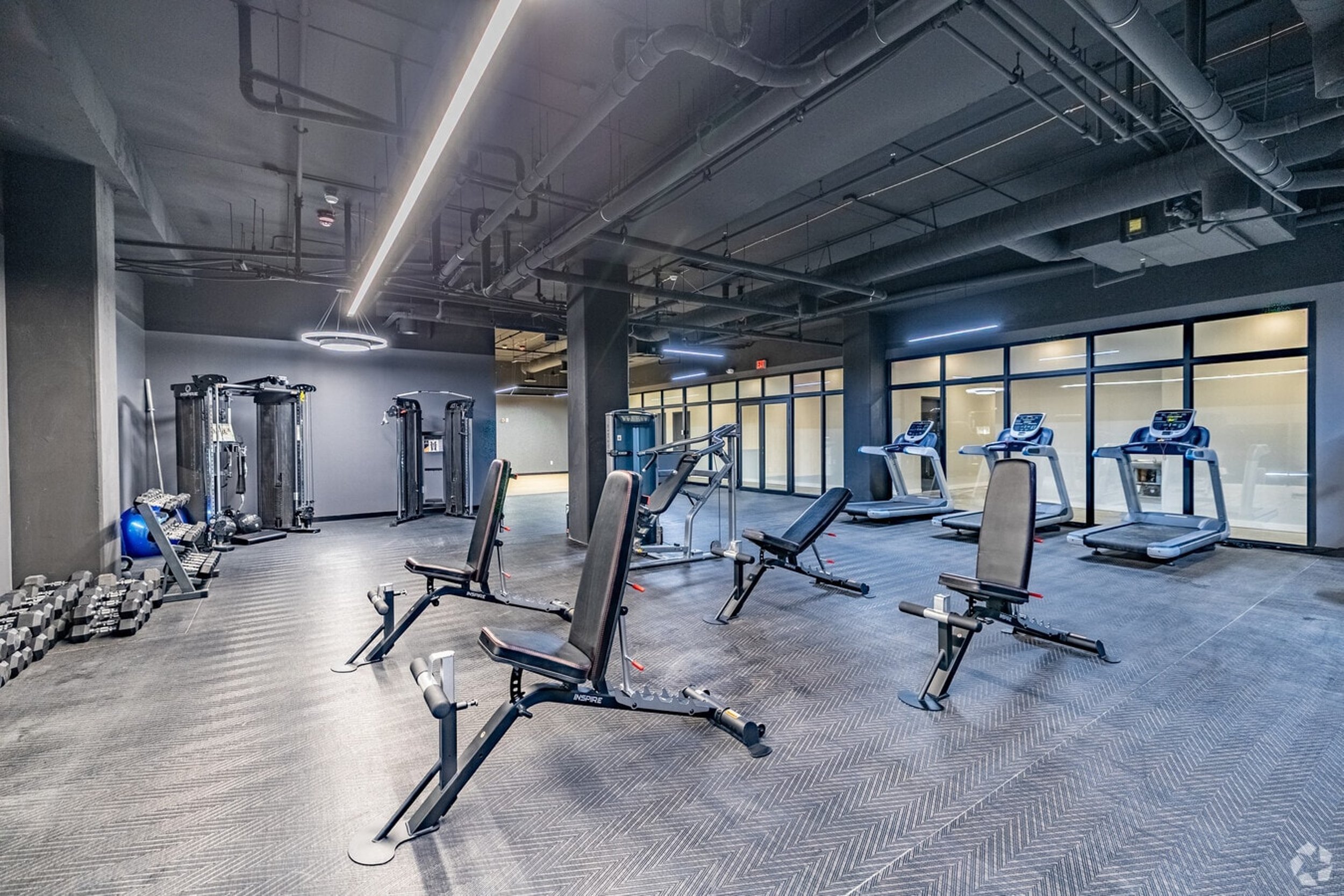 Modern gym, fitness center at luxury apartment complex in Tulsa Oklahoma. Free weights, gym equipment, machines for working out.