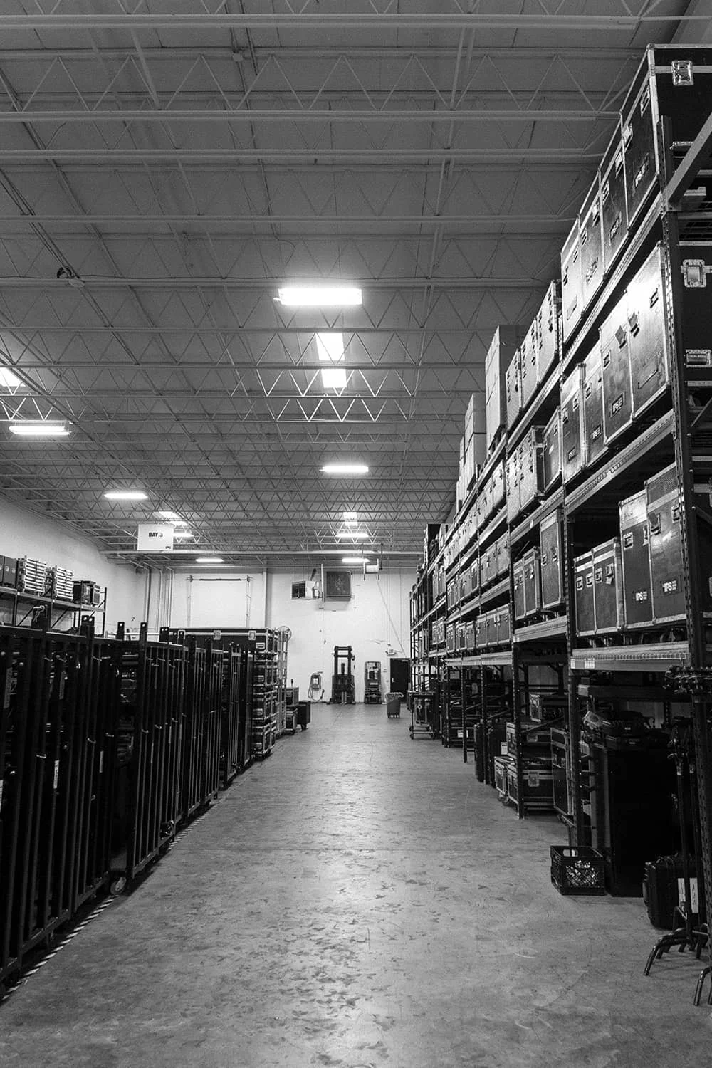 Empty warehouse aisle with metal shelving units holding boxes and equipment.