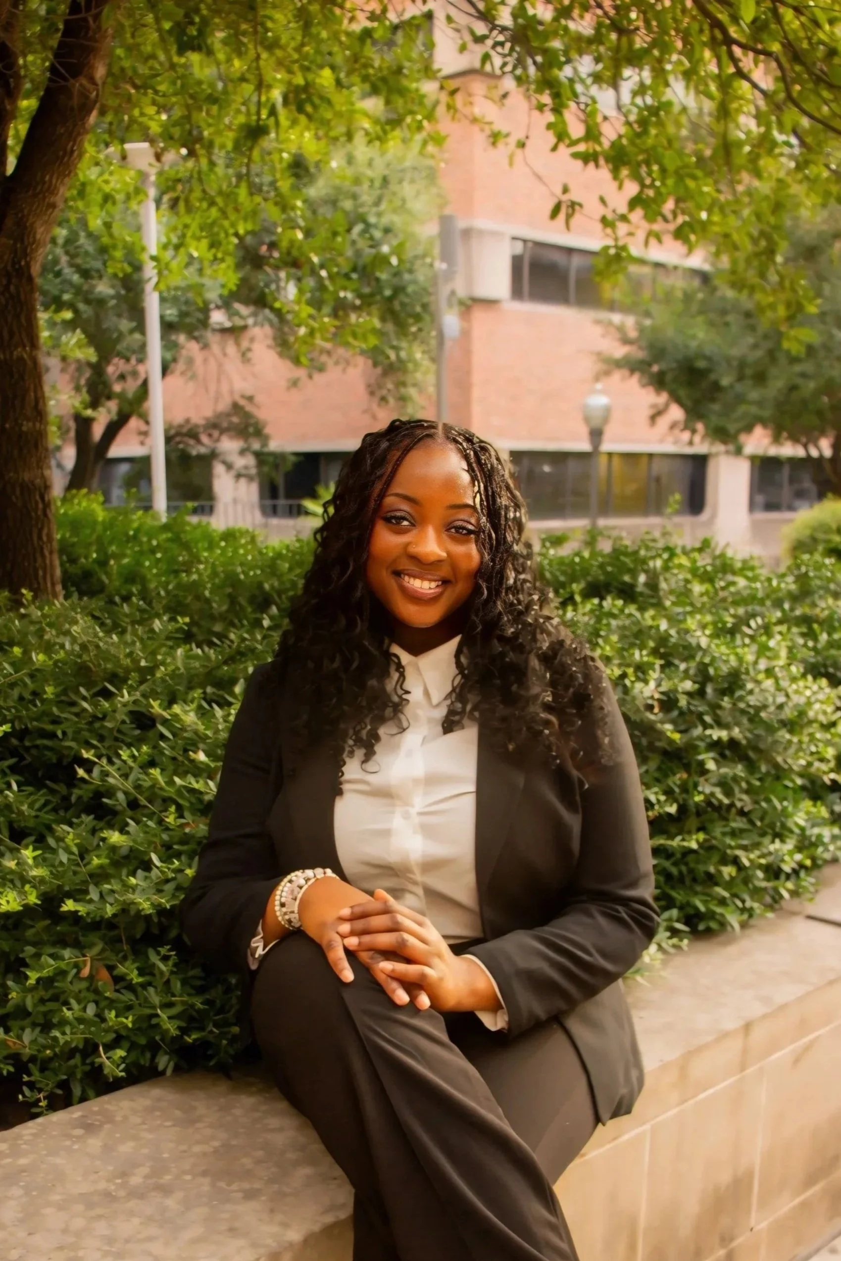 Woman with curly hair wearing white shirt and pearl headband