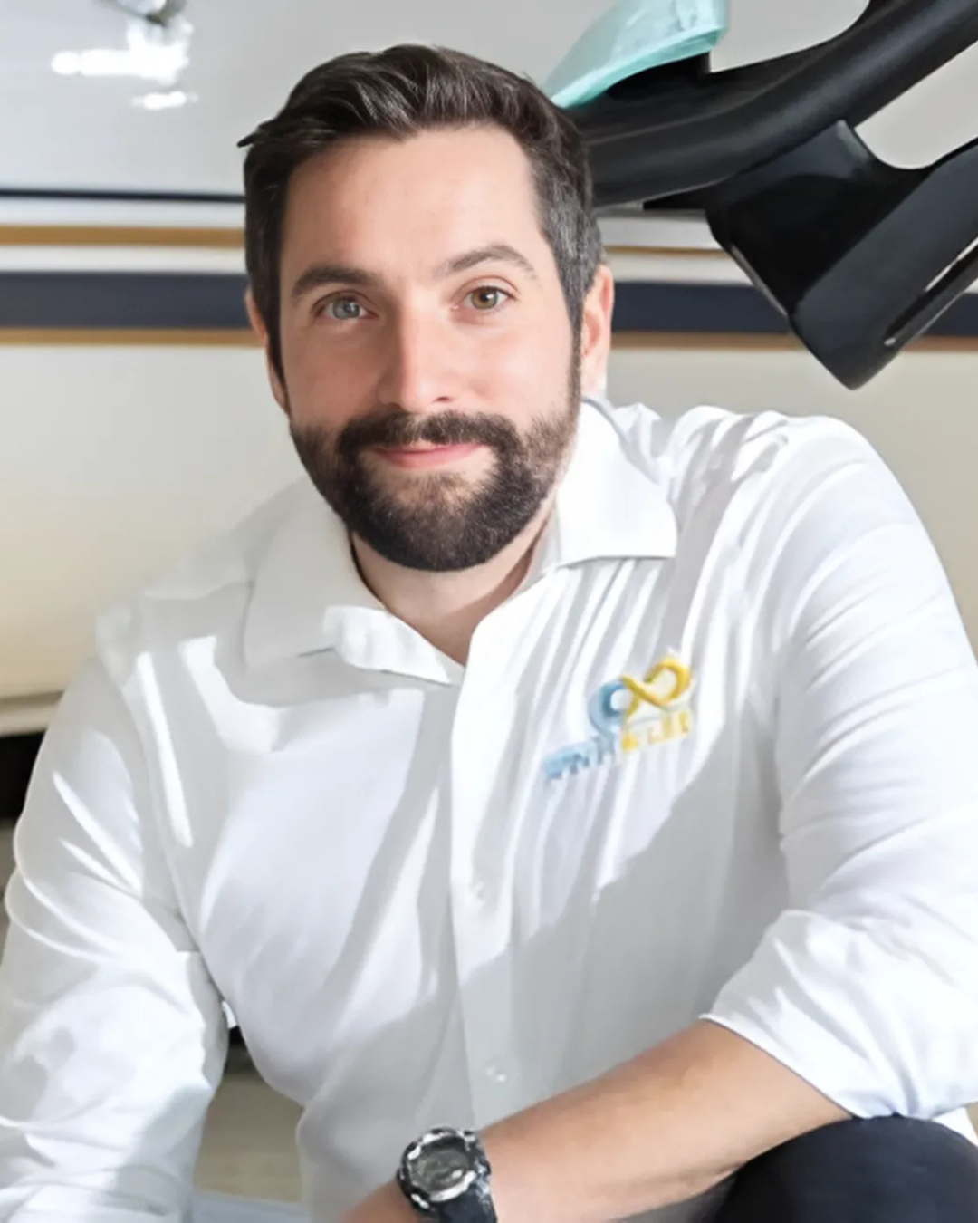 Steve Klintberg Nagy, co-founder of Virtu Venture, RocketHouse, and Spin For Life, wearing a white button-up shirt with a company logo. He has dark hair, a beard, and a warm smile. He is seated in a bright, modern setting with a sleek, black structur