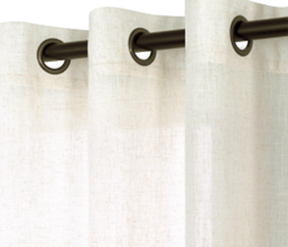 Close-up of beige curtains hanging from metal curtain rings on a curtain rod.