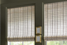 Two windows with bamboo blinds, and a small picture frame between them.