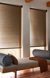 Living room with two closed window blinds, a wooden bench with cylindrical cushions, and a hardwood floor.