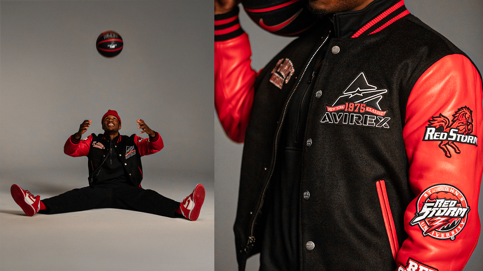 A man in a black and red varsity jacket with patches and embroidery, sitting on the floor with legs spread wide, juggling a black and red basketball against a plain gray background.