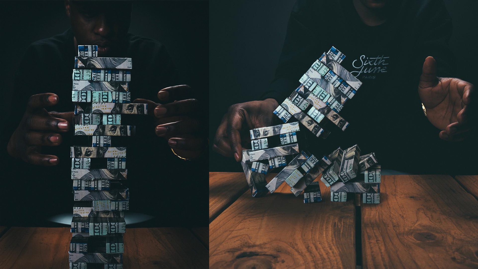 Close-up of a person playing a Jenga game made of folded dollar bills in a dark setting, with a wooden table visible.