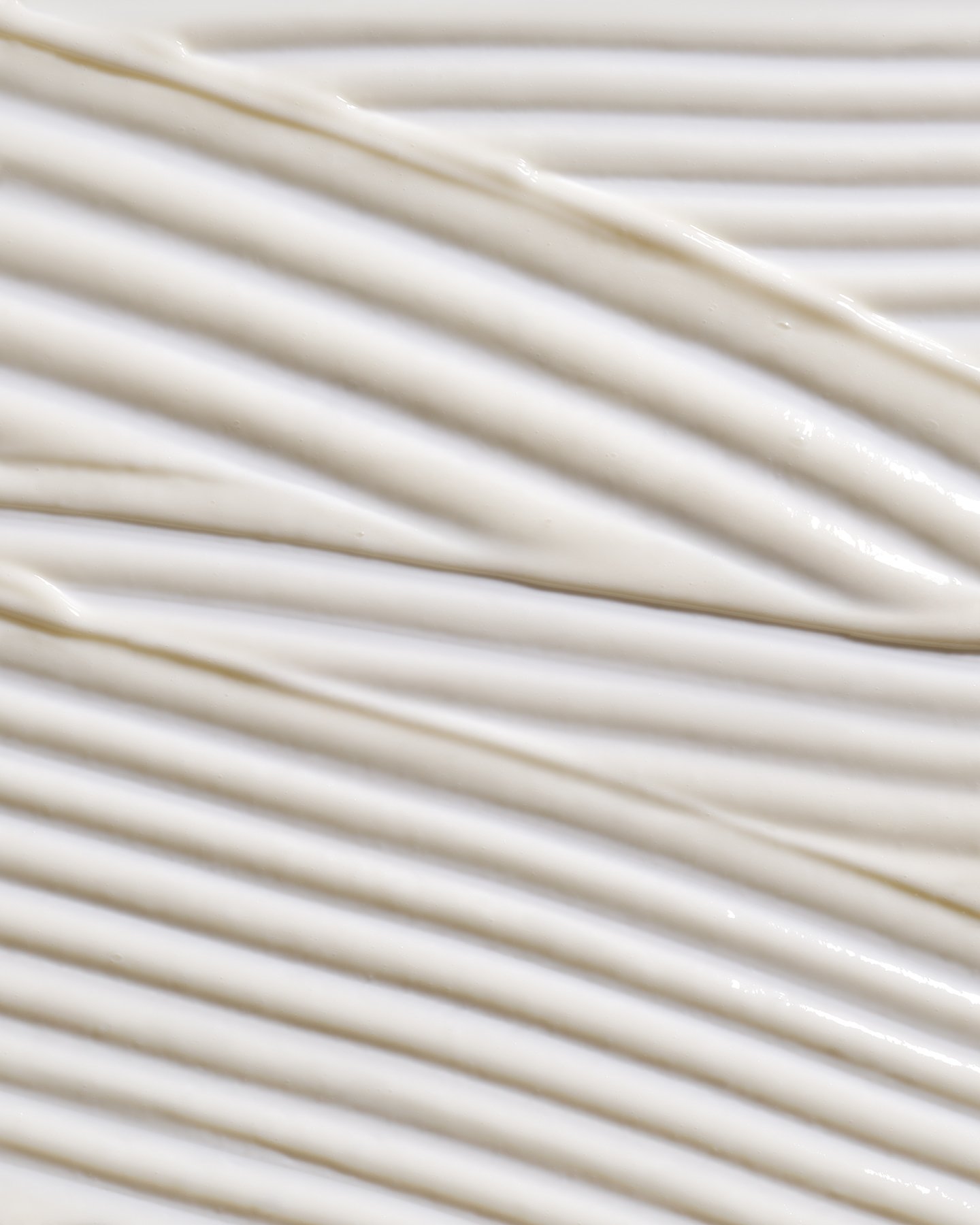 Close-up of white cream or frosting with parallel grooves.