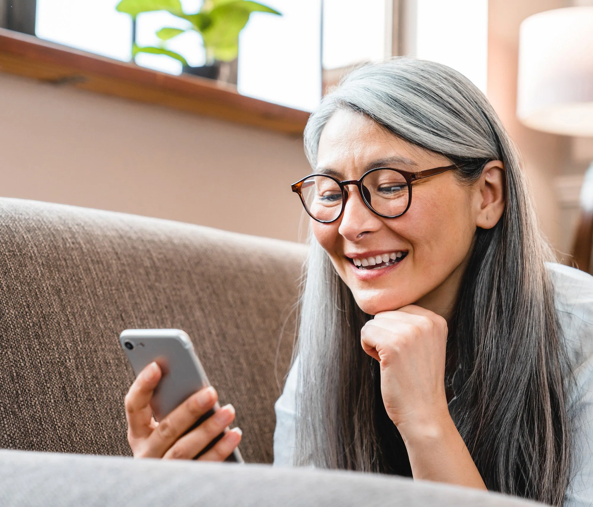 Woman looking at phone happy to have BH services