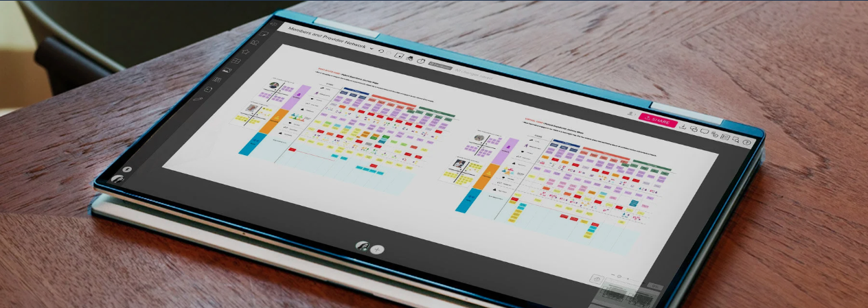 A tablet displaying a colorful schedule or chart on a wooden table.