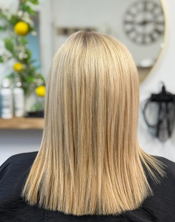 Back of a woman with straight blonde hair in a salon