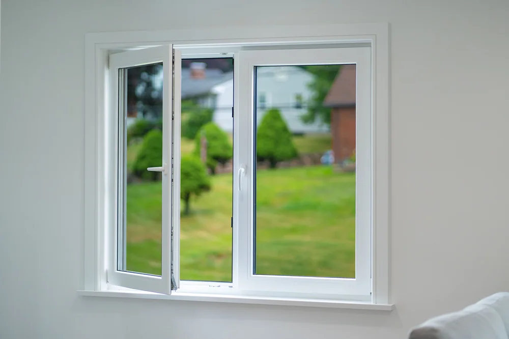 Open GALAA tilt-and-turn window overlooking a green lawn