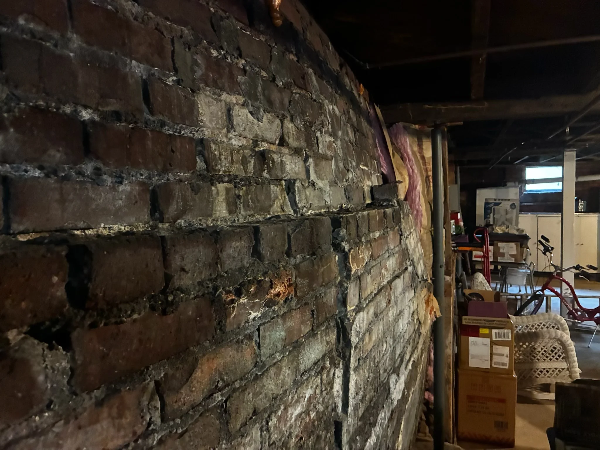 bowing and cracking basement wall caused by moisture and foundation damage