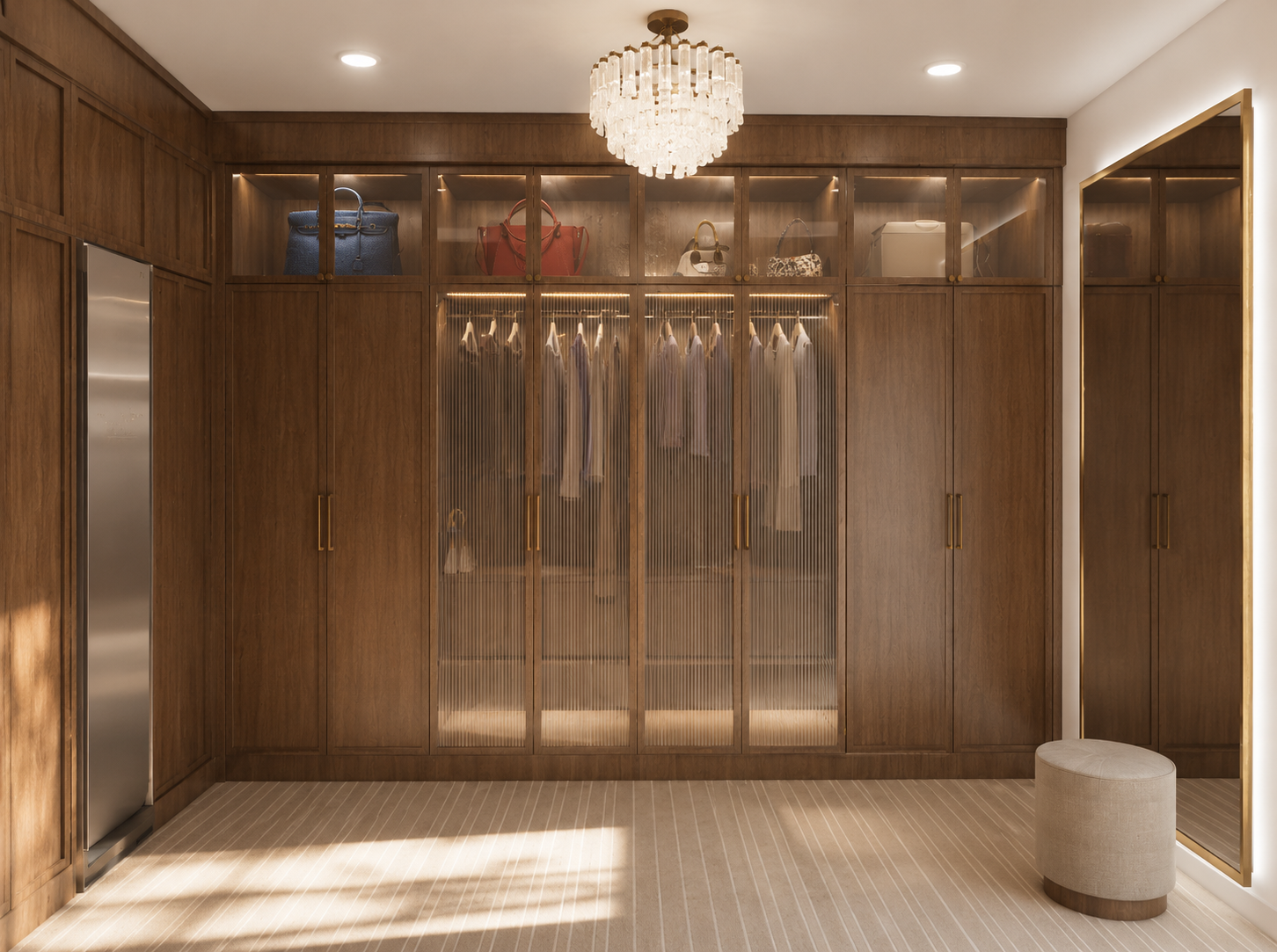 A wooden closet with glass doors, open to reveal hanging clothes, handbags, and storage boxes, with a chandelier overhead and a small round stool nearby.